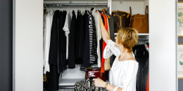 Woman hanging clothes in closet
